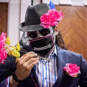 Un catrín con presencia muestra su ropa y flores