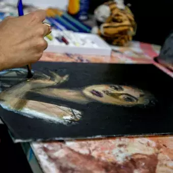 Estudiante pintando una mujer seria