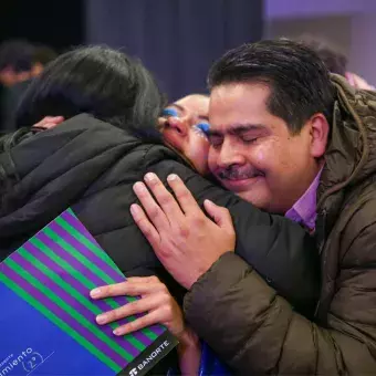 Padres de familia abrazando a su hija