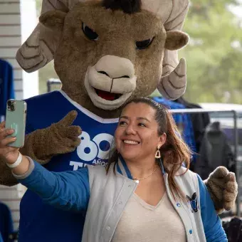 Mujer tomándose foto con Teus, la mascota del Tec