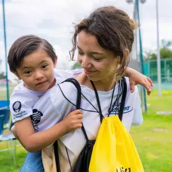 Alumna cargando a niño