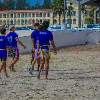 grupo de alumnos haciendo deporte en playa miramar
