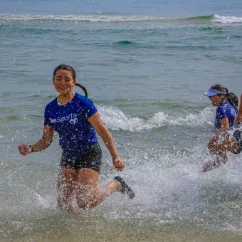 Alumnos divirtiéndose en la orilla de la playa
