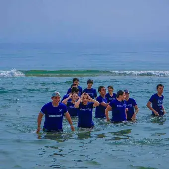 alumnos refrescándose en la orilla de la playa