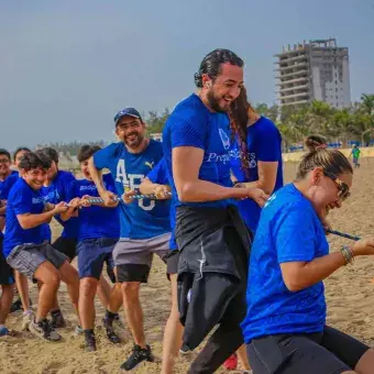 profesores jugando a la cuerda en la playa