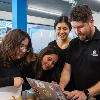 Estudiantes con coach preparándose para FIRST