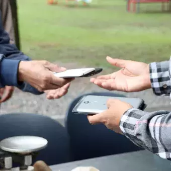 Hombre entrega celulares para campaña de reciclaje, en campus Monterre