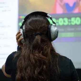 Vista de espaldas de una chica con audífonos. 