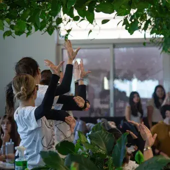 Alumnas bailando entre mesas de una cafetería. 