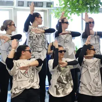 7 chicas acomodadas de forma que los dibujos en sus camisetas forman un dibujo de Picaso. 