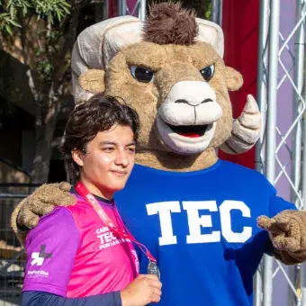 Persona tomándose una foto mostrando su medalla con Teus en la Carrera Tec.