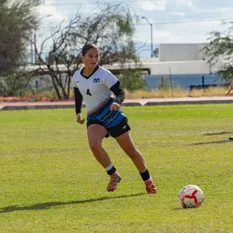 Tres chicas jugando fútbol. 