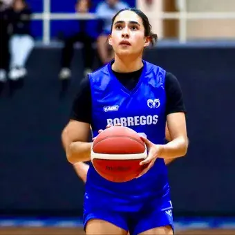 Jugador de básquetbol concentrada mirando el aro durante un tiro de castigo en la línea.