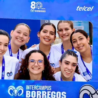 Equipo femenil de voleibol celebra su primer lugar tomándose una foto.
