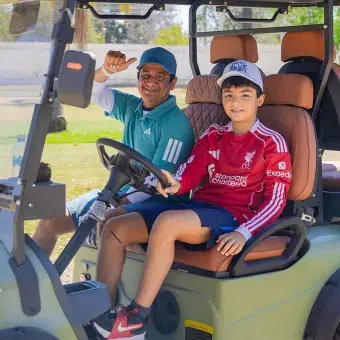 jugadores del torneo en carro de golf