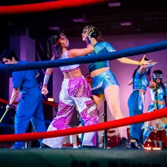 Estudiantes caracterizadas como luchadoras realizan coreografía sobre un ring durante el espectáculo "Los Sonidos del Ring"